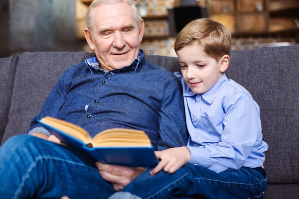 Könyvmoly Szép Kisfiú Olvasás Könyvet Nagyapja Miközben Együtt Ült Kanapén — Stock Fotó
