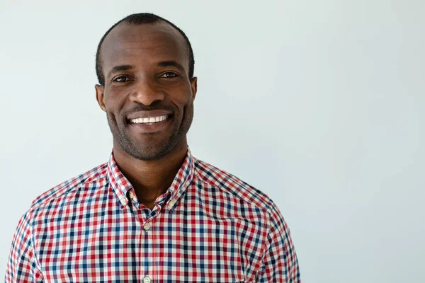 Yükselen ruh hali. Neşeli yakışıklı afro amerikan adam beyaz arka plan karşı gülümseyen