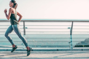 Konsantre sporcu köprüde açık havada koşarken hızlı hareket ediyor. Web sitesi afişi