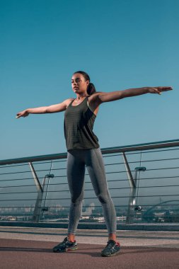 Sakin genç atlet egzersiz yaparken elleri yana doğru köprüde ayakta