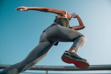 Koşarken diz koyarak spor giysiler içinde atlet alt görünümü