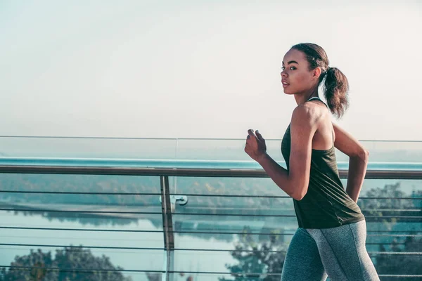 Señora Tranquila Ropa Deportiva Mirando Distancia Mientras Corre Por Puente — Foto de Stock