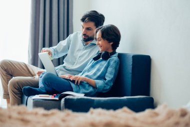 Meraklı yetişkin bir adam elinde modern bir dizüstü bilgisayarla ekranı işaret ediyor ve gülümsüyor.