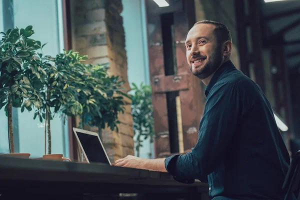 Vrolijke Knappe Jonge Man Zit Met Een Moderne Laptop Het — Stockfoto