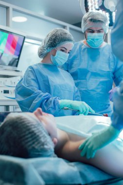 Ameliyathanede ameliyat yaparken dikkatli çalışan deneyimli doktorlar.