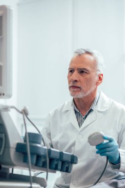 Modern bir ultrason tarayıcısı üzerinde çalışan ciddi deneyimli bir sonograf.