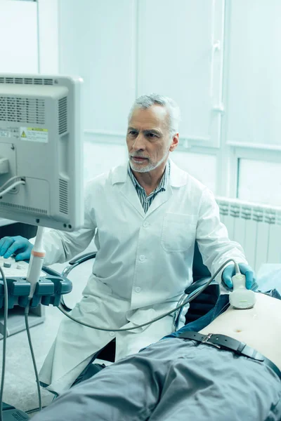 Médico Serio Sentado Cerca Del Paciente Con Transductor Ultrasonido Mirando — Foto de Stock