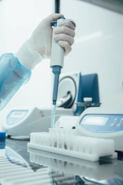 Laboratuvar teknisyeninin rafında test tüpleri olan otomatik bir pipet makinesi kullanmasını engelle.