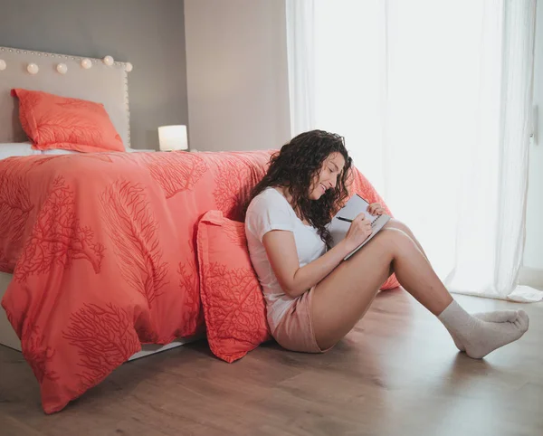 Yatak odasında onun günlüğü yazma yatağın yanında katta oturan genç kadın