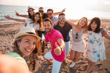 Parti mutlu çok ırklı genç insanları bir yaz aylarında oldukları sırada sahilde bir selfie yapma. Arkadaşları ve tatil kavramı