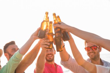 Şerefe! Mutlu gençlerin grup Beach bira şişesi ile kızartma. Kutlama kavramı 