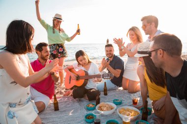 Çok kültürlü bir grup arkadaşıyla birlikte beach mutlu genç insanlar yaz tatili kutlama parti. Yaz saati ve tatil kavramları.