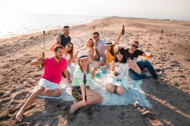 Çok kültürlü bir grup arkadaşıyla birlikte beach mutlu genç insanlar yaz tatili kutlama parti. Yaz saati ve tatil kavramları.