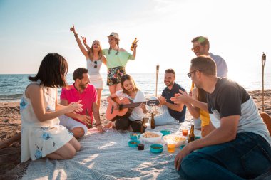 Çok kültürlü bir grup arkadaşıyla birlikte beach mutlu genç insanlar yaz tatili kutlama parti. Yaz saati ve tatil kavramları.