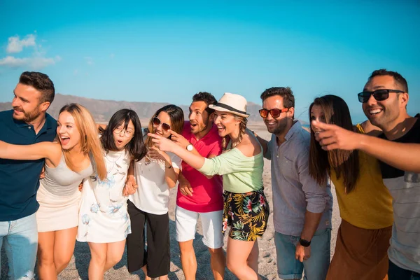 Multicultural group of friends partying on the beach - Young people celebrating during summer vacation, summer time and holidays concepts