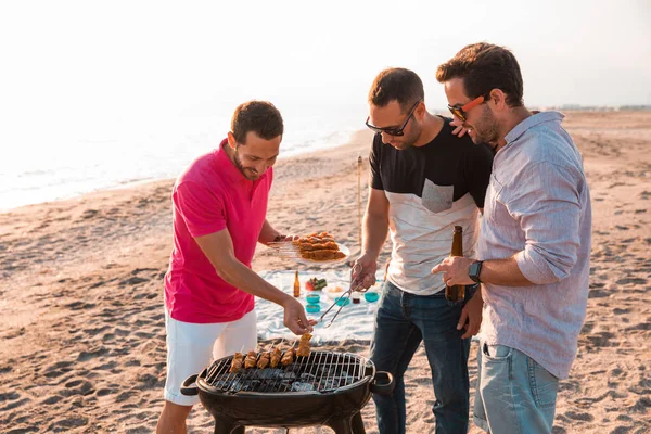 Sahilde Barbekü hazırlanıyorlar iken mutlu arkadaşlar eğlenmeye mı. Tatil kavramı.