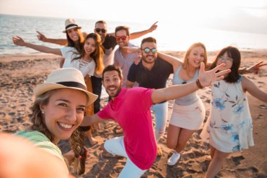 Bir yaz parti oldukları sırada mutlu çok ırklı genç insanlar plajda bir selfie yapıyoruz. Arkadaşları ve tatil kavramı