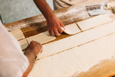 Baker kesme ve geleneksel ekmek fırın rustik bir tablo hazırlamak için hamur yoğurma. Fırın kavramı.