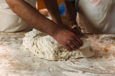 Baker ekmek fırın rustik bir tablo hazırlamak için hamur yoğurma. Geleneksel ekmek kavramı.