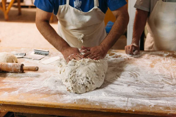 Baker ekmek fırın rustik bir tablo hazırlamak için hamur yoğurma. Geleneksel ekmek kavramı.