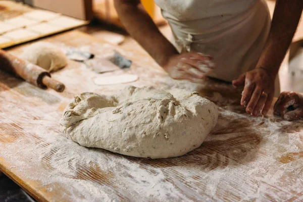 Baker ekmek fırın rustik bir tablo hazırlamak için hamur yoğurma. Geleneksel ekmek kavramı.