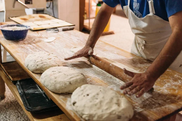 Baker ekmek fırın rustik bir tablo hazırlamak için hamur yoğurma. Geleneksel ekmek kavramı.
