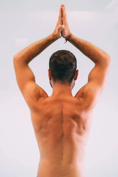 Yoga. Young man doing yoga exercise isolated on a white background. Yogi master workout on white urban studio. Yoga lifestyle healthy concept.