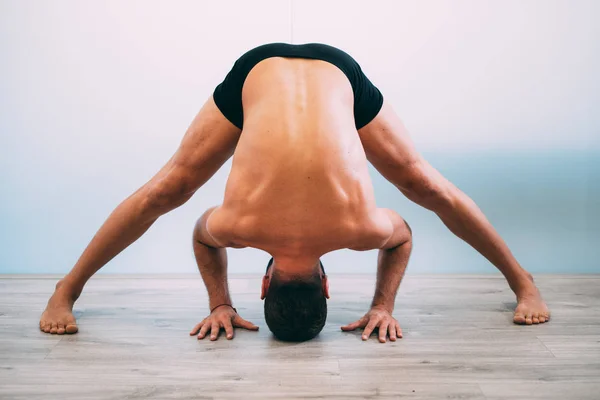 Yoga. Young man doing yoga exercise isolated on a white background. Yogi master workout on white urban studio. Yoga lifestyle healthy concept.