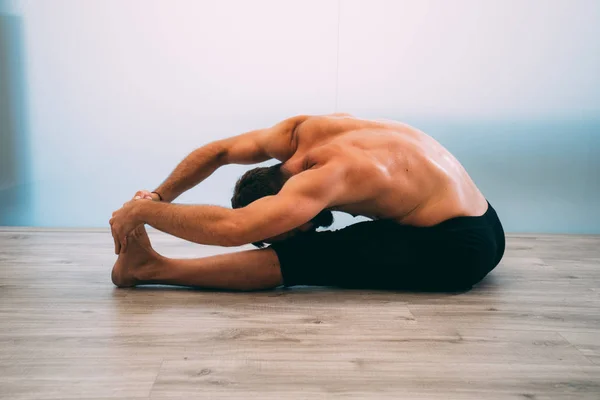 Yoga. Young man doing yoga exercise isolated on a white background. Yogi master workout on white urban studio. Yoga lifestyle healthy concept.