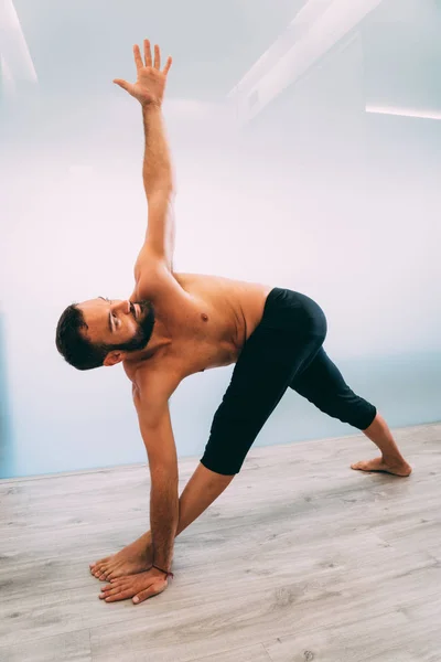 Yoga. Young man doing yoga exercise isolated on a white background. Yogi master workout on white urban studio. Yoga lifestyle healthy concept.