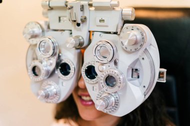 Gülümseyen kadın optik phoropter görme ölçüm yapıyor