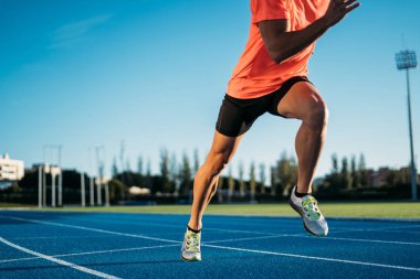 Genç sporcu adam bir başlangıç konumu bir yarışta çalışmasına başlamak üzere. Adım başlamak 