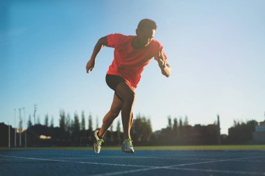 Genç sporcu adam bir başlangıç konumu bir yarışta çalışmasına başlamak üzere. Adım başlamak 