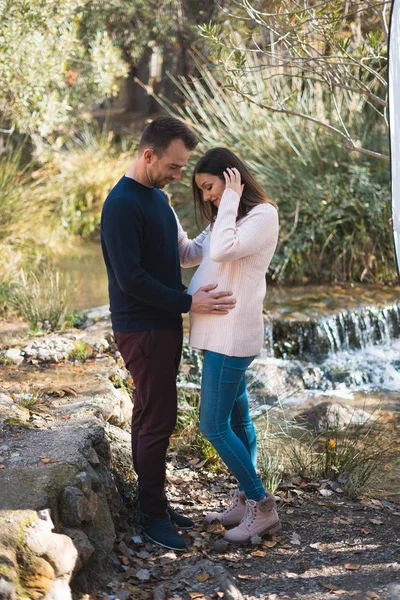 Junges Paar Erwartet Baby Lächelt Und Umarmt Ihren Bauch — Stockfoto