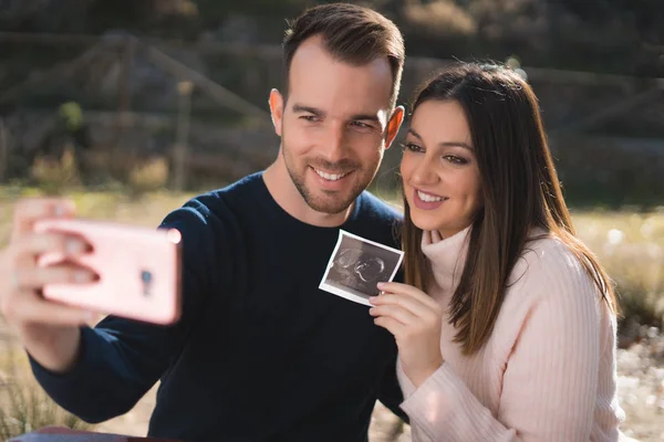 Schwangere Und Ihr Mann Machen Draußen Ein Selfie Mit Ultraschallbild — Stockfoto