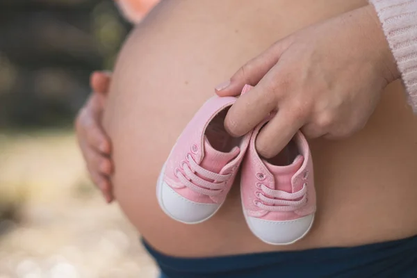 Беременная Женщина Улице Держит Детскую Обувь Животу — стоковое фото