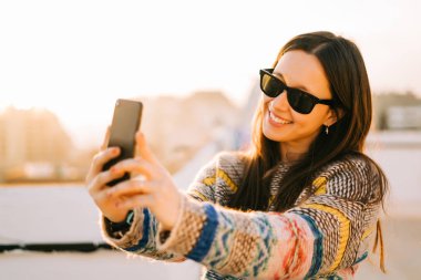 New York'ta bir terasta selfie alarak güneş gözlüğü ile mutlu genç kadın