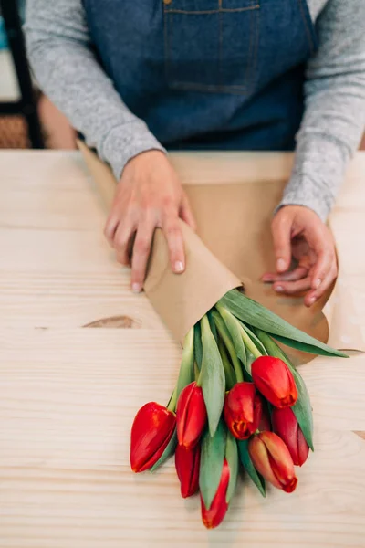 Mann Florist Macht Roten Tulpenstrauß Und Verpackung Packpapier Auf Holztisch — Stockfoto