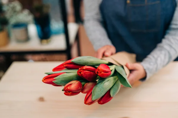 Hombre Florista Hace Ramo Tulipán Rojo Envolver Papel Paquete Mesa — Foto de Stock