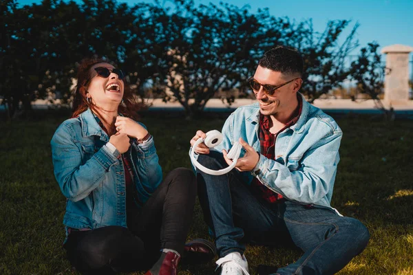 Feliz jovem casal apaixonado ouvir música com fones de ouvido e h — Fotografia de Stock