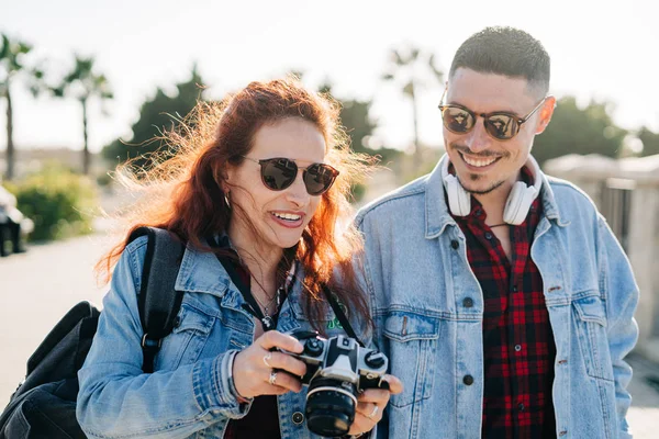 Casal feliz de turistas fotografando em um parque em um dia ensolarado — Fotografia de Stock