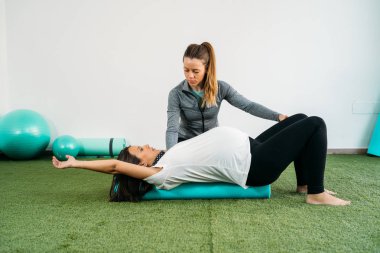 Hamile kadın coac ile fitness topu ve pilates egzersiz yapıyor