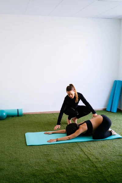 Pregnant woman doing fitness ball and pilates exercise with coac