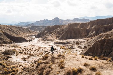 Güneşli bir günde büyük bir çölün yollarında yürüyen gezgin bir adam