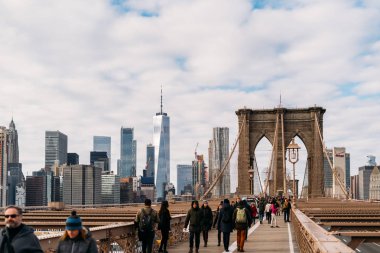 New York, Amerika Birleşik Devletleri, Aralık 25, 2108: Birçok turist bulutlu bir günde arka planda New York city ile Brooklyn Köprüsü boyunca yürüyüş 