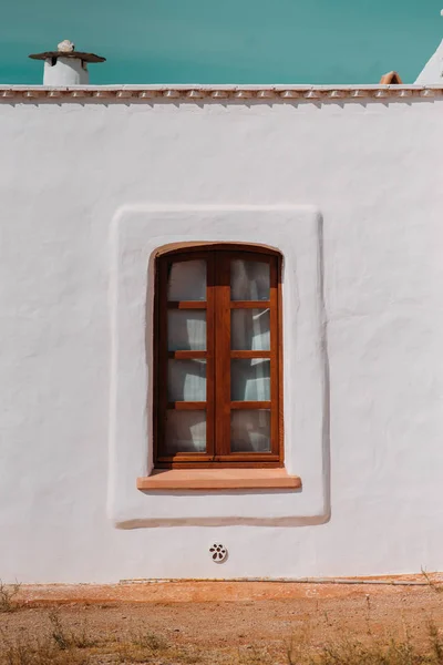 Rustic window closed with wooden exterior shutters on white background. Mediterranean traditional house.
