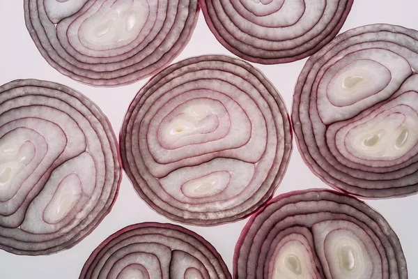 Pattern of red onion slices on a white background. Top view, flat lay. Food