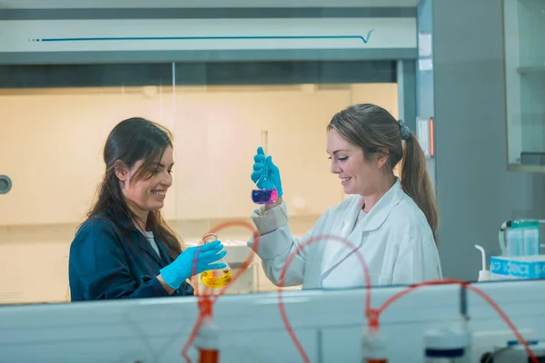 Dos jóvenes científicas haciendo experimentos en laboratorio . — Foto de Stock