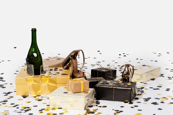 Christmas background with gift boxes, confetti, bottle and glasses of champagne and party shoes. Preparation for holidays and parties. Top view with copy space. — Stock Photo, Image