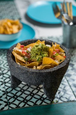 Biftek, guacamole, erimiş peynir, biber ve kişniş yapraklarıyla süslenmiş sarı mısır cipsi. Geleneksel Meksika havanı..